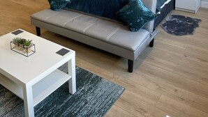 Ein modernes Schlafzimmer mit Bett, Nachttischen, Schreibtisch und einer Couch.