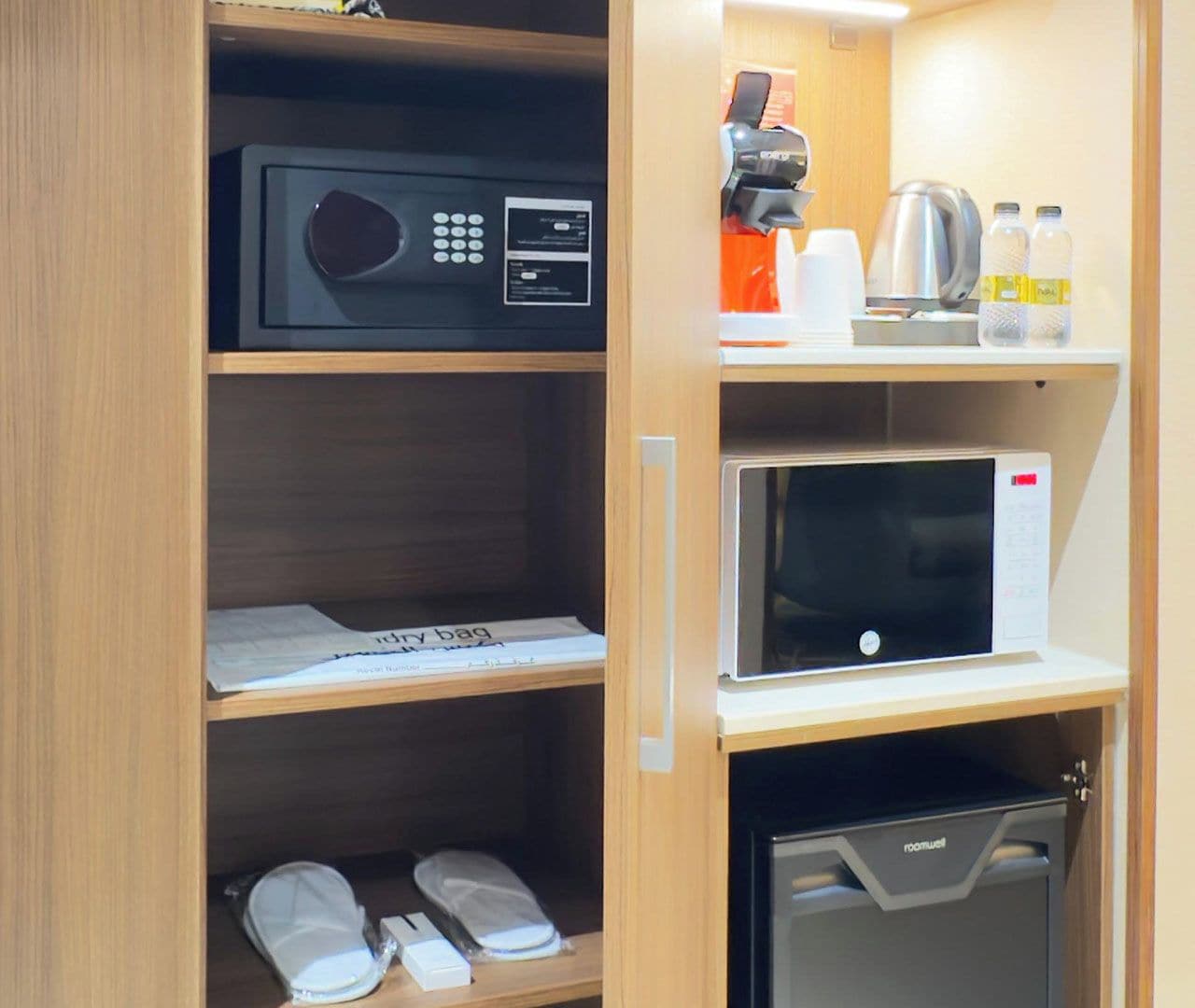Habitación de hotel con microondas, cafetera y refrigerador pequeño.