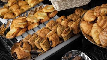 A buffet with various pastries and bread.