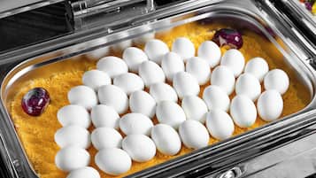 Una bandeja con huevos y pan rallado.