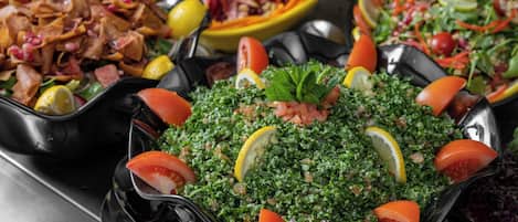 On propose une variété de plats, dont une salade copieuse à base de tomates et de tranches de citron.