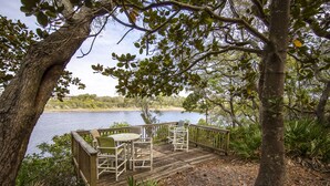 A wooden deck with outdoor furniture overlooking a body of water. -  Lake front, with Gulf View! 10 min walk to beach. (Santa Rosa Beach)