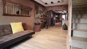 A spacious living area with a sofa, a coffee table, and a staircase leading to an upper level.