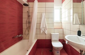 Ein Badezimmer mit Badewanne, Toilette und Waschbecken.