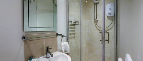 A modern bathroom with a glass-enclosed shower, a white sink, and a mirror above it.