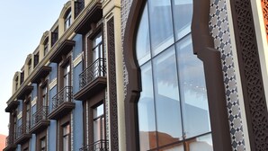 Un edificio a più piani con un'ampia finestra ad arco e decorazioni in maioliche.