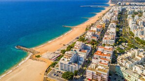 Un paisaje urbano costero con playa y rascacielos.