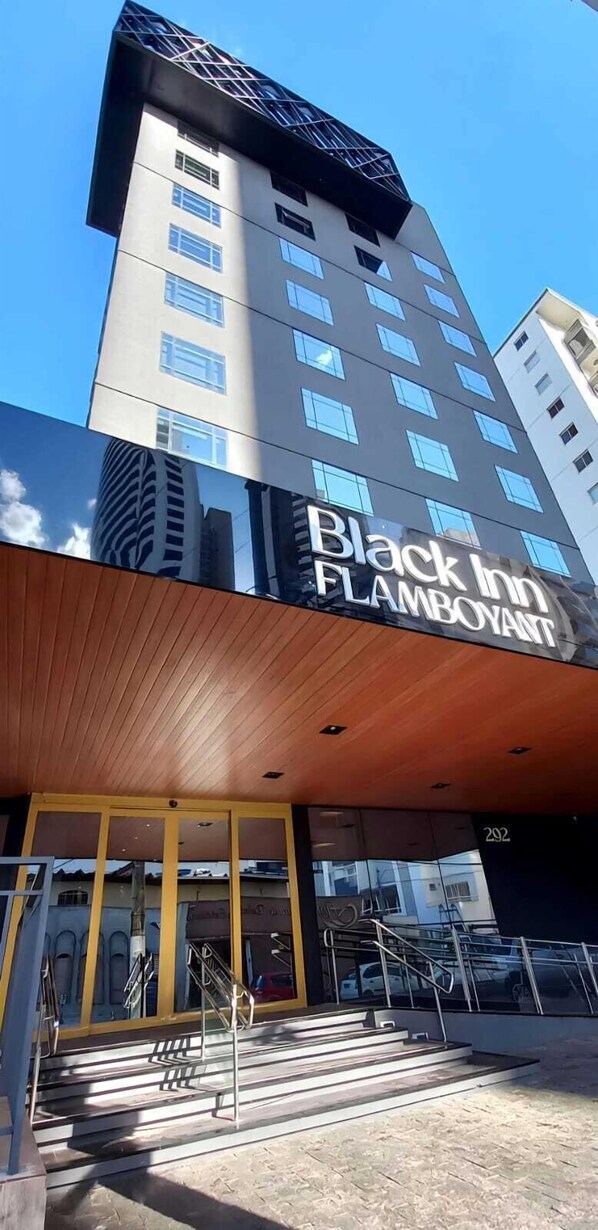 A modern building with a prominent sign for Black Inn Flamboyant.