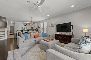 Relax in a spacious living room with a sectional sofa, coffee table, and flat-screen TV.