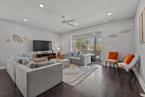 Relax in this stylish living room with a comfortable sofa, flat-screen TV, and large window offering a view of the outdoors.
