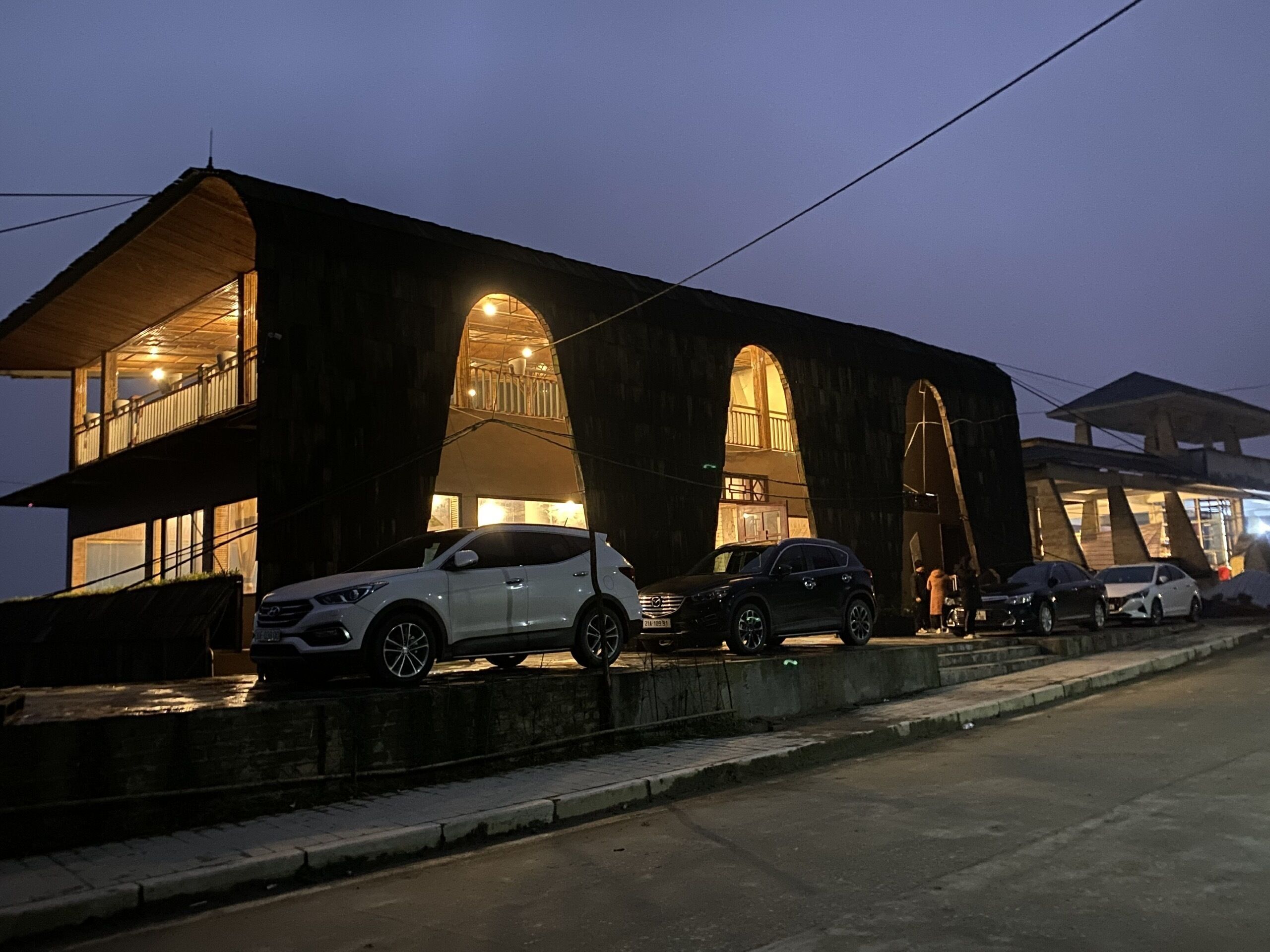 A modern building with a unique arched design, featuring multiple levels and large windows.
