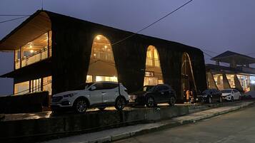 A modern building with a unique arched design, featuring multiple levels and large windows.