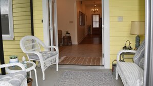 A room with a white wicker sofa, a small round table, and a patterned rug. - "Henrietta's Magnolia" Located 2 1/2 blocks from historic downtown Breaux Bridge (Breaux Bridge)
