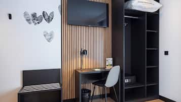 A modern room with a wooden slatted wall, a desk with a chair, a black shelving unit, and a black trash bin.