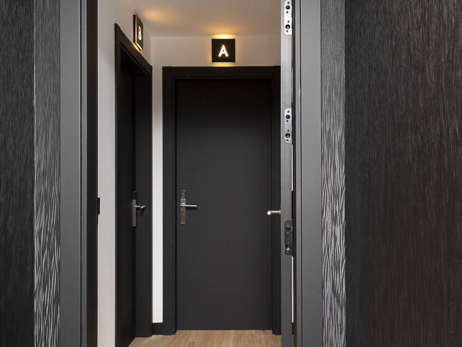 A modern hotel entrance with a dark wood finish, a sign indicating room number 307, and a visible door with a handle.