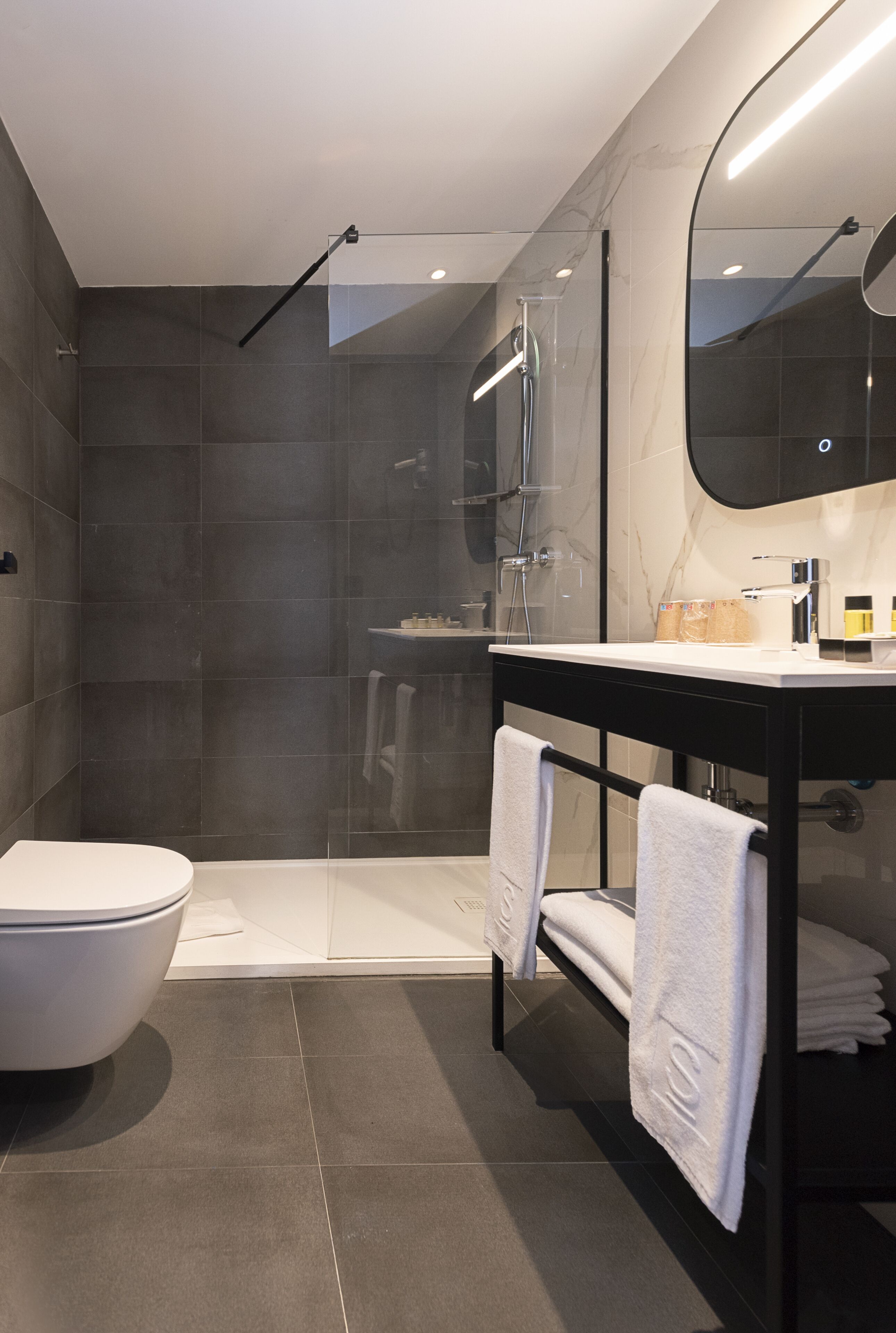 A modern bathroom with a shower, toilet, and vanity.
