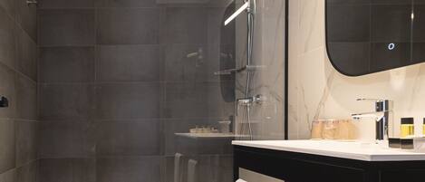 A modern bathroom with a shower, toilet, and vanity.