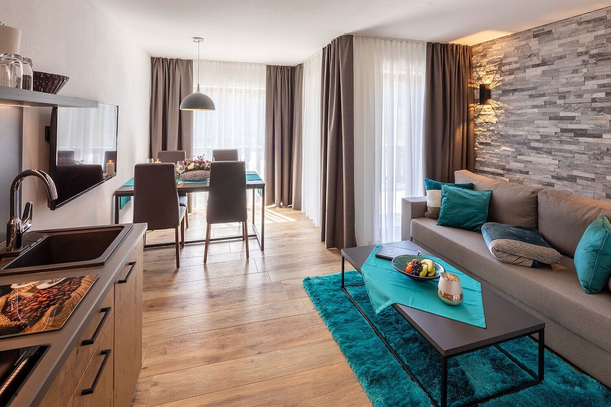 A modern living room with a sofa, coffee table, and dining area.