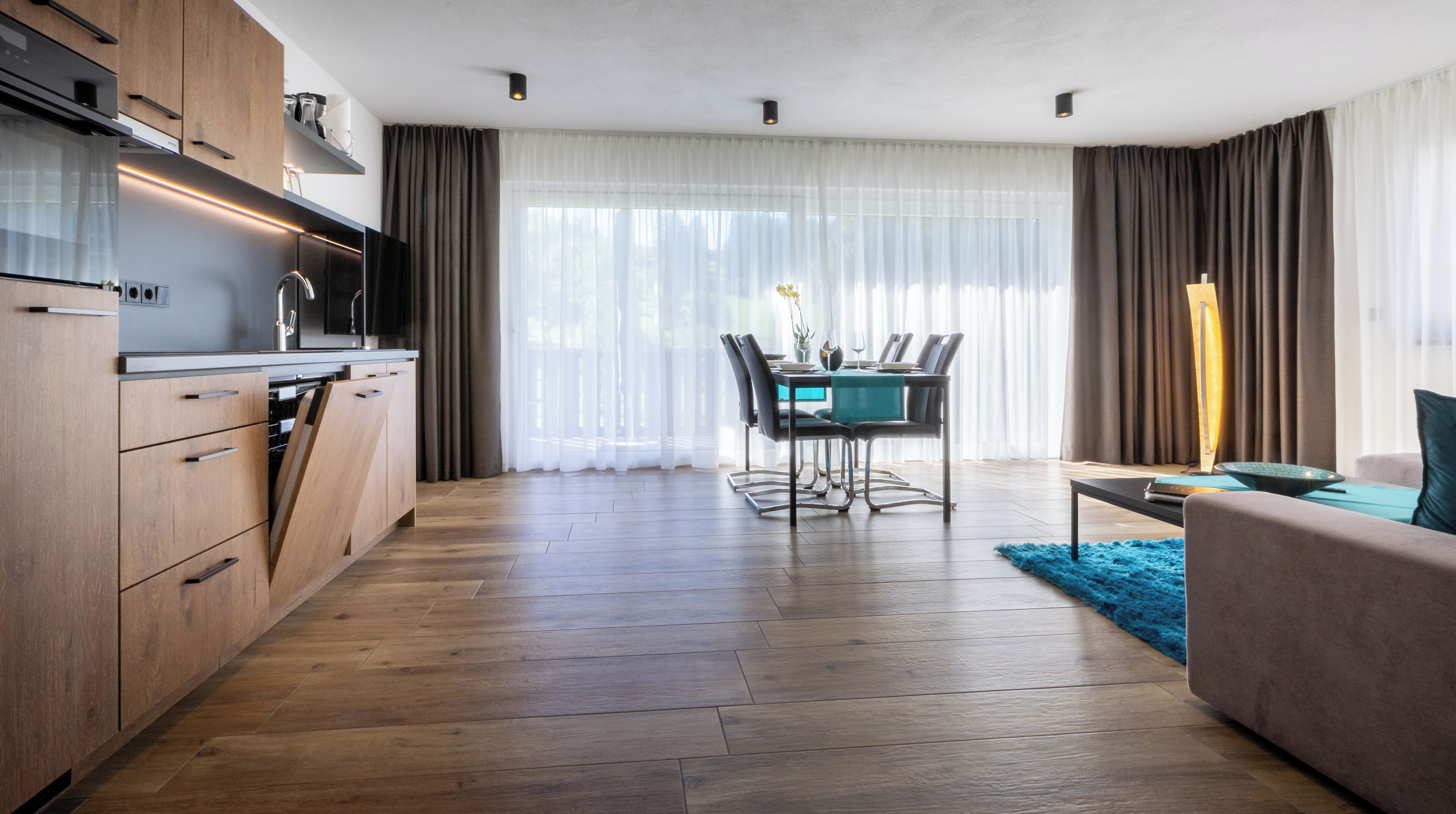 Une cuisine moderne avec des meubles en bois et un coin repas comprenant une table et des chaises.