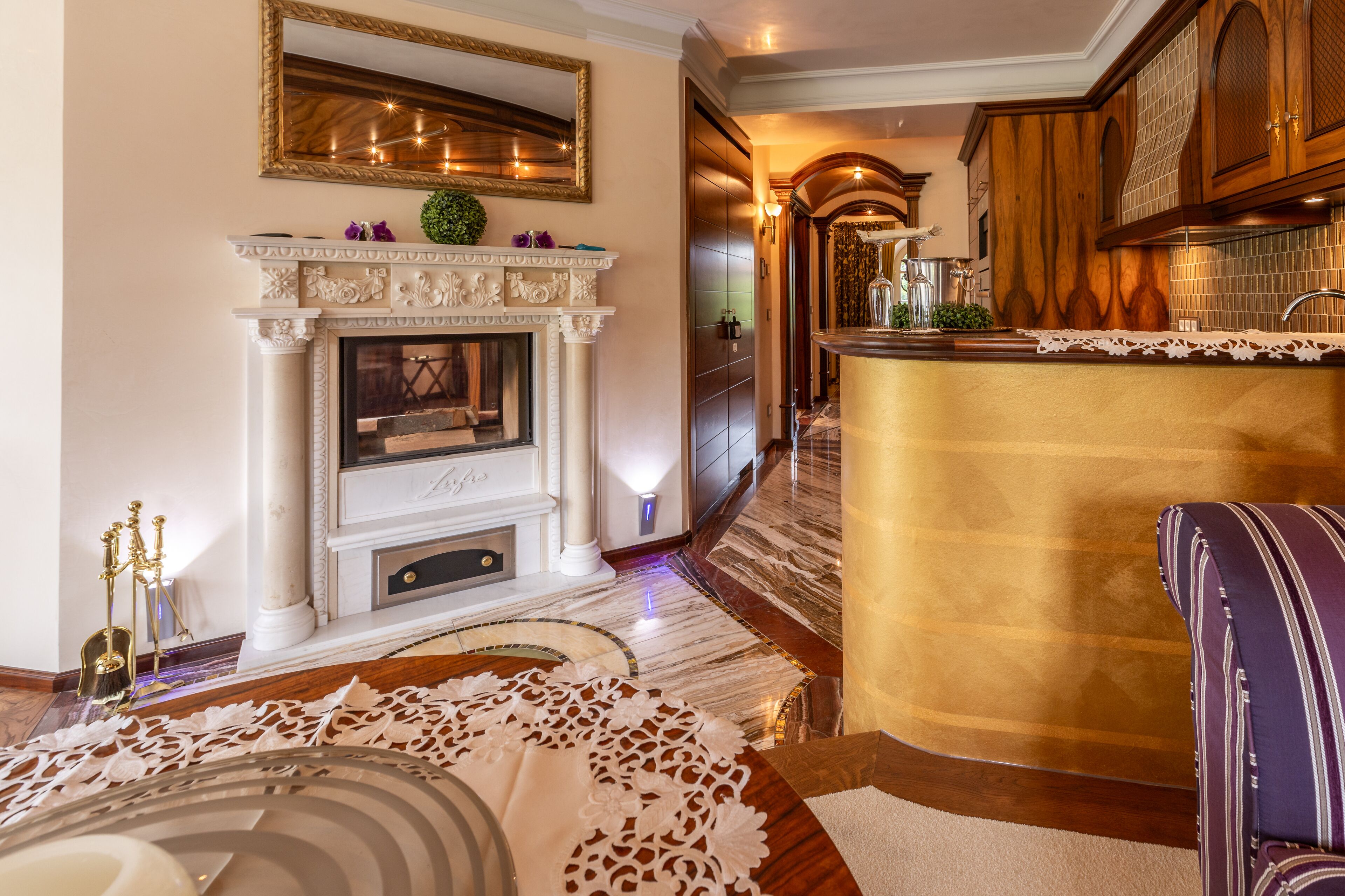Una sala de estar lujosa con chimenea, una zona de bar y un pasillo bien iluminado.