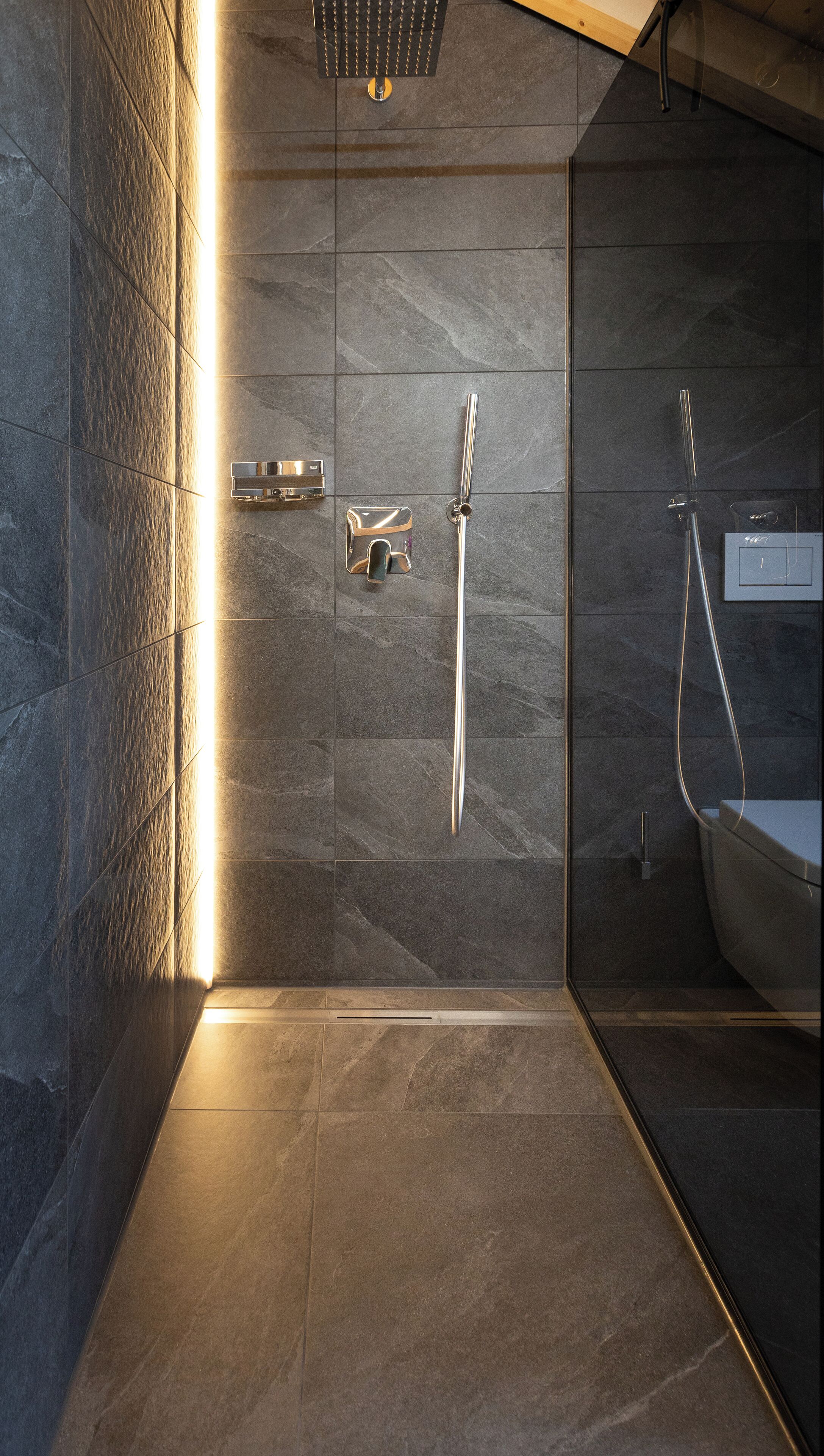 Une salle de bain moderne équipée d’une douche, de toilettes et d’un lavabo.