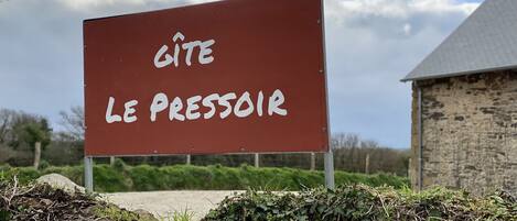A sign with the text "GITE LE PRESSAIR" in a rural setting.