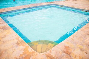 Et rektangulært swimmingpool med flisekant og stenkant.
