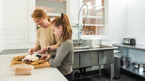 Une cuisine moderne avec des carreaux blancs, des appareils en acier inoxydable et un plan de travail en bois.