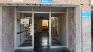 A building entrance with marble walls and a black marble floor. There are glass doors with a sign above them. - Baroque 10-person Apartment in Makrygialos (Pydna-Kolindros)