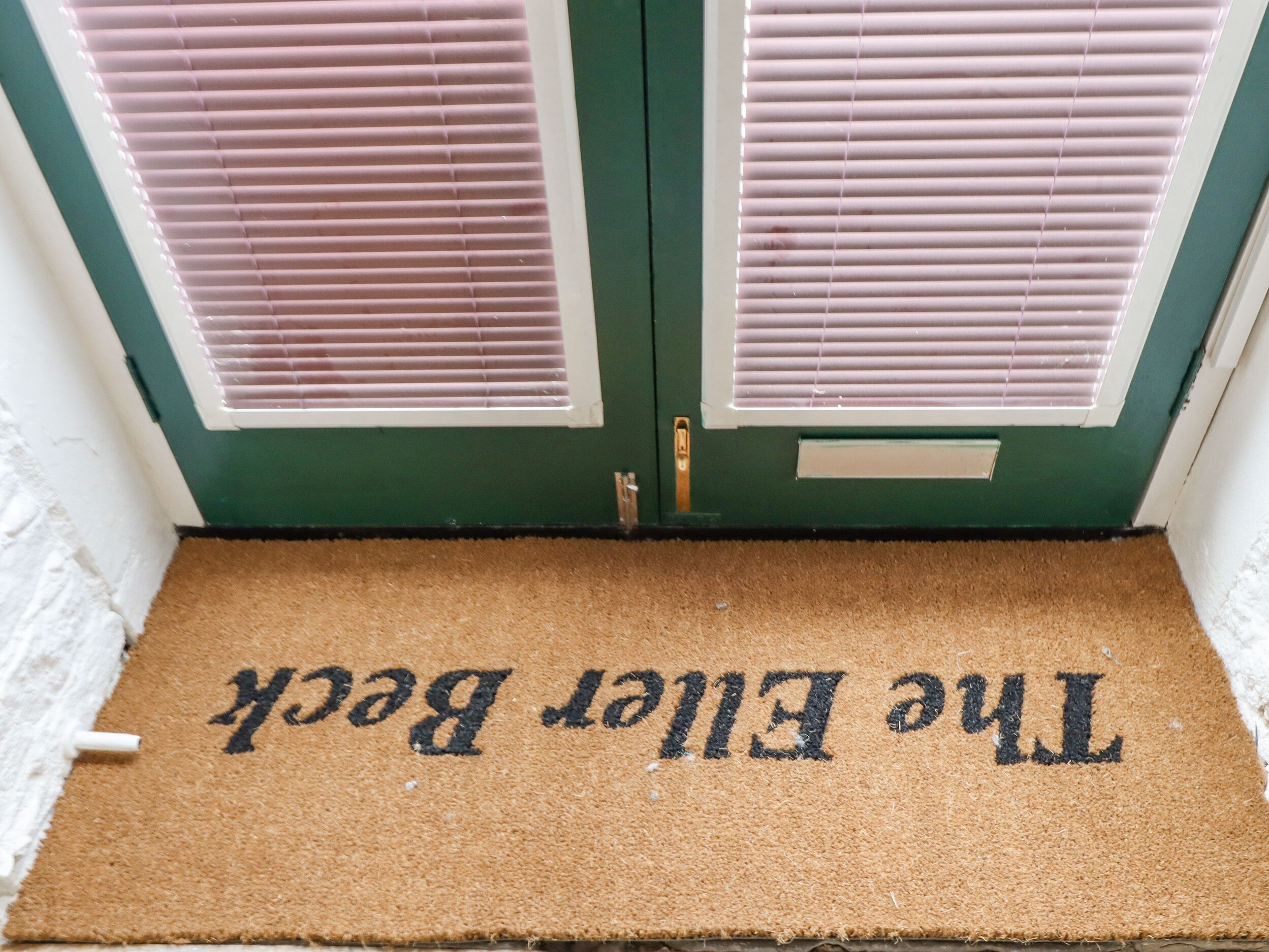 Eine Tür mit Fußmatte, auf der steht: The Front Door.