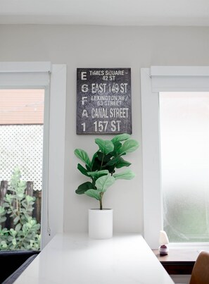 Simple, functional space with a potted plant and a chalkboard sign above a table.
