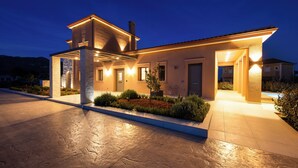Una casa moderna con un amplio camino de entrada, un porche cubierto y una puerta principal bien iluminada.