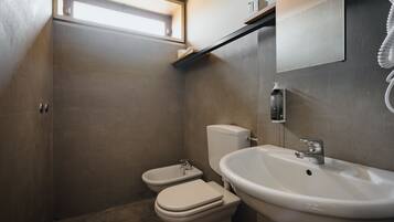 A bathroom with a toilet, bidet, and sink.