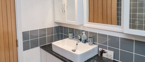 A bathroom with a white sink, a mirror, and a cabinet.