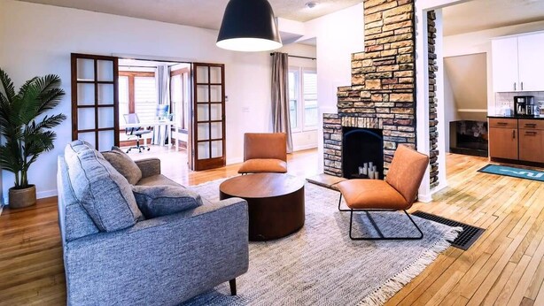 A living room with a sofa, armchair, coffee table, and a fireplace.