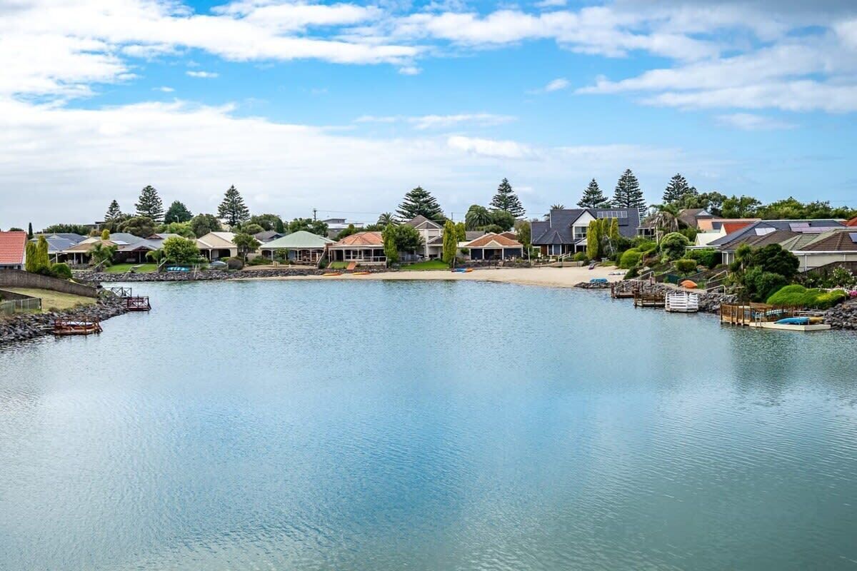 A lakeside residential area with houses, docks, and a calm water body.
