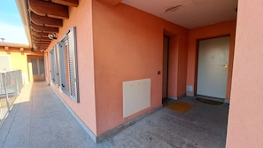A corridor with a tiled floor, a door, and a radiator.