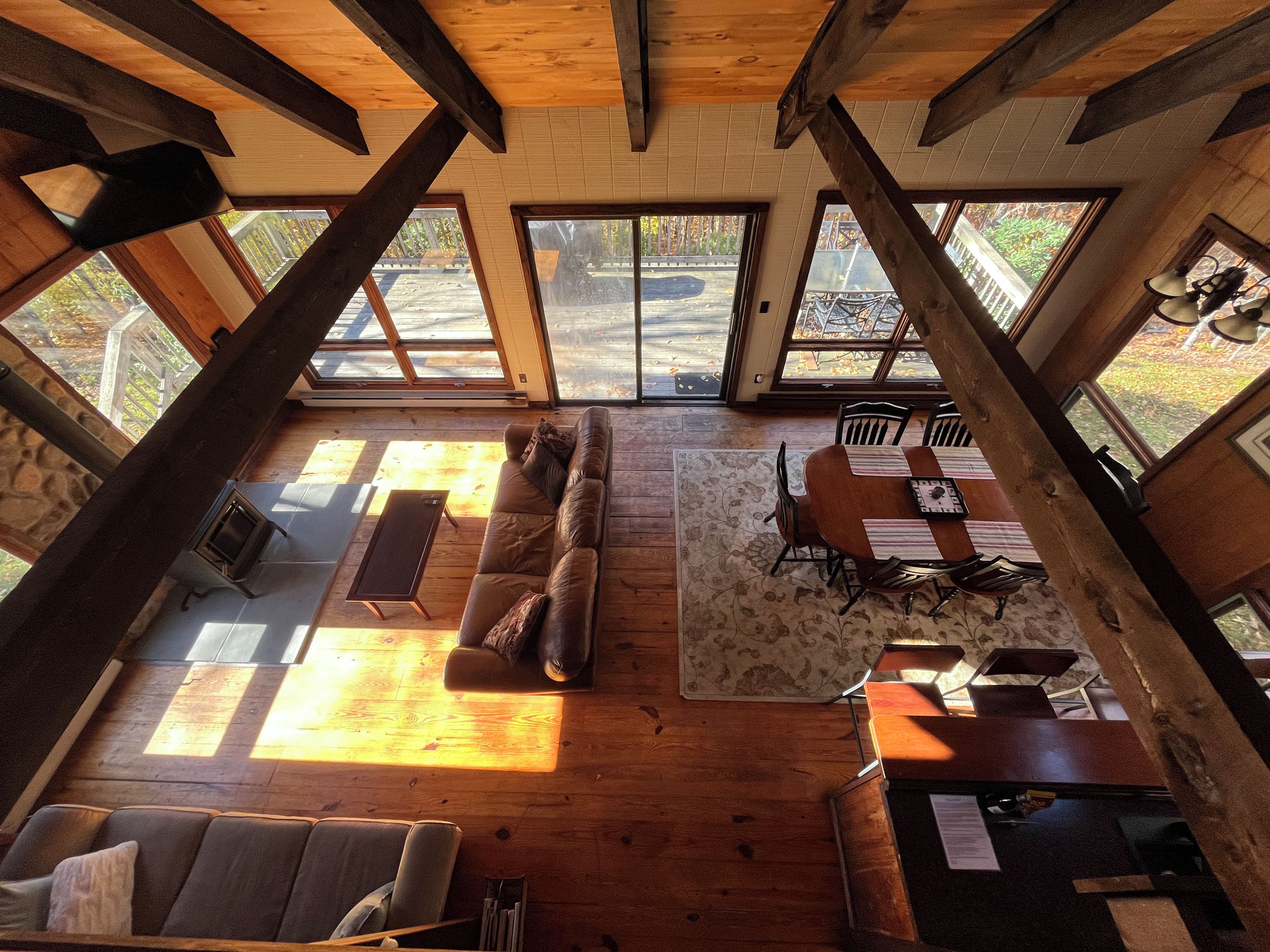 Un loft amplio con techo alto, ventanas grandes, un sofá, una mesa de comedor y una chimenea.