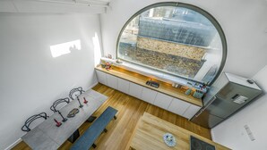 A compact kitchen with a large window, a built-in bench, and a dining table. - Unique Light-Filled Three-Bedroom Mews House (london)