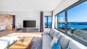 A modern living room with a large TV, a sofa, and a coffee table. - Villa Astera -heated pool, 4 bedrooms, and sea views (Seget Vranjica)