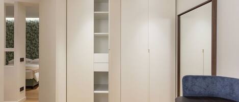 Une chambre moderne avec une grande armoire, une table de chevet et une chaise.