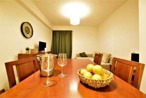 A dining table with a fruit bowl, wine glasses, and a pitcher. - 2 Bedroom Condo in Albufeira (Albufeira)