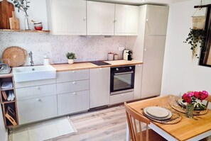 Enjoy cooking in this well-equipped kitchen with a stainless steel sink, oven, and dining table.