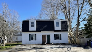 A two-story house with a front porch, a garage, and a driveway.