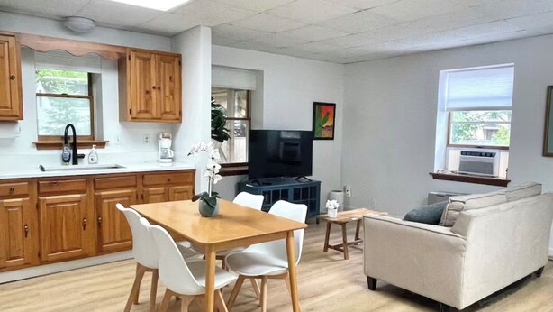 A modern living space with a kitchen, dining area, and a sofa.