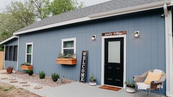 Welcome to Creed's Cottage, a charming residence with a cozy porch and lush greenery.