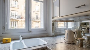 Una cucina con un lavello doppio, un bollitore e una macchina del caffè sul piano di lavoro.