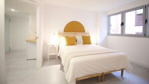 Un dormitorio con cama, escritorio y ventana.
