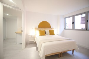 Un dormitorio con cama, escritorio y ventana.
