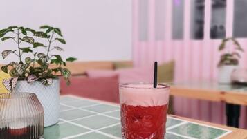 Ein Tisch mit einem Glas roter Flüssigkeit und einer dekorativen Vase.